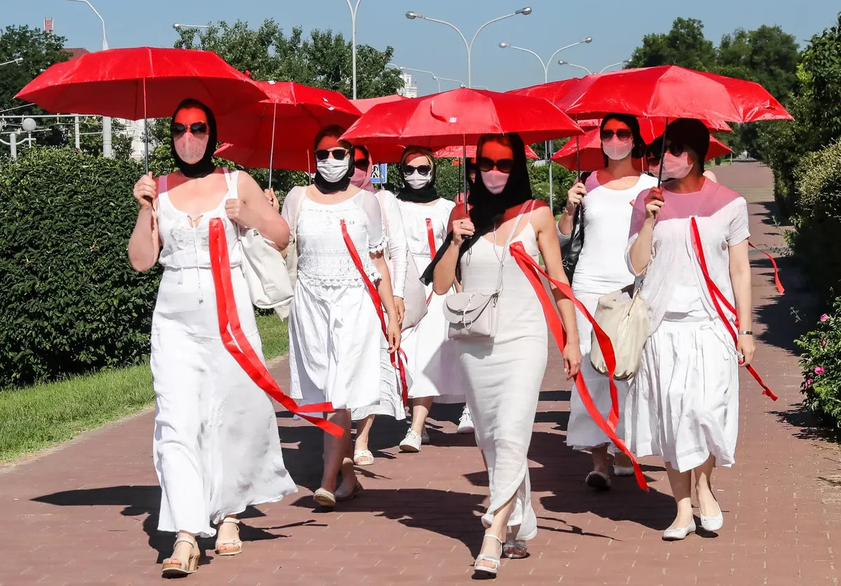 Belarusian women wearing the colours of a Belarusian protest flag march during a protest against dictator Alexander Lukashenko in Minsk, Belarus, 21 June 2021. Photo: EPA-EFE