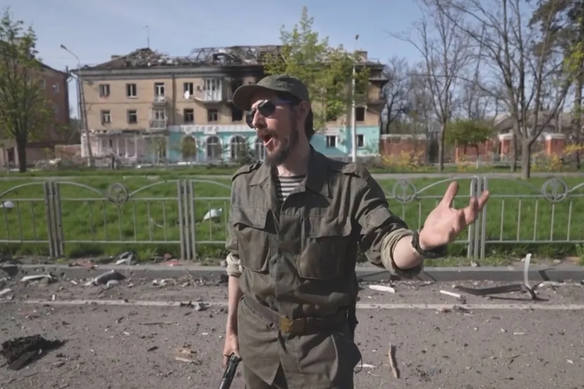 Франсуа Мод Д’Эме поёт на улице разрушенного Мариуполя. Кадр из фильма «Театр военных действий». Источник: RT:Doc / <a data-sk="tooltip_parent" data-stringify-link="https://t.me/ClubArtel/201" href="https://t.me/ClubArtel/201" rel="noopener noreferrer" target="_blank">Telegram</a>